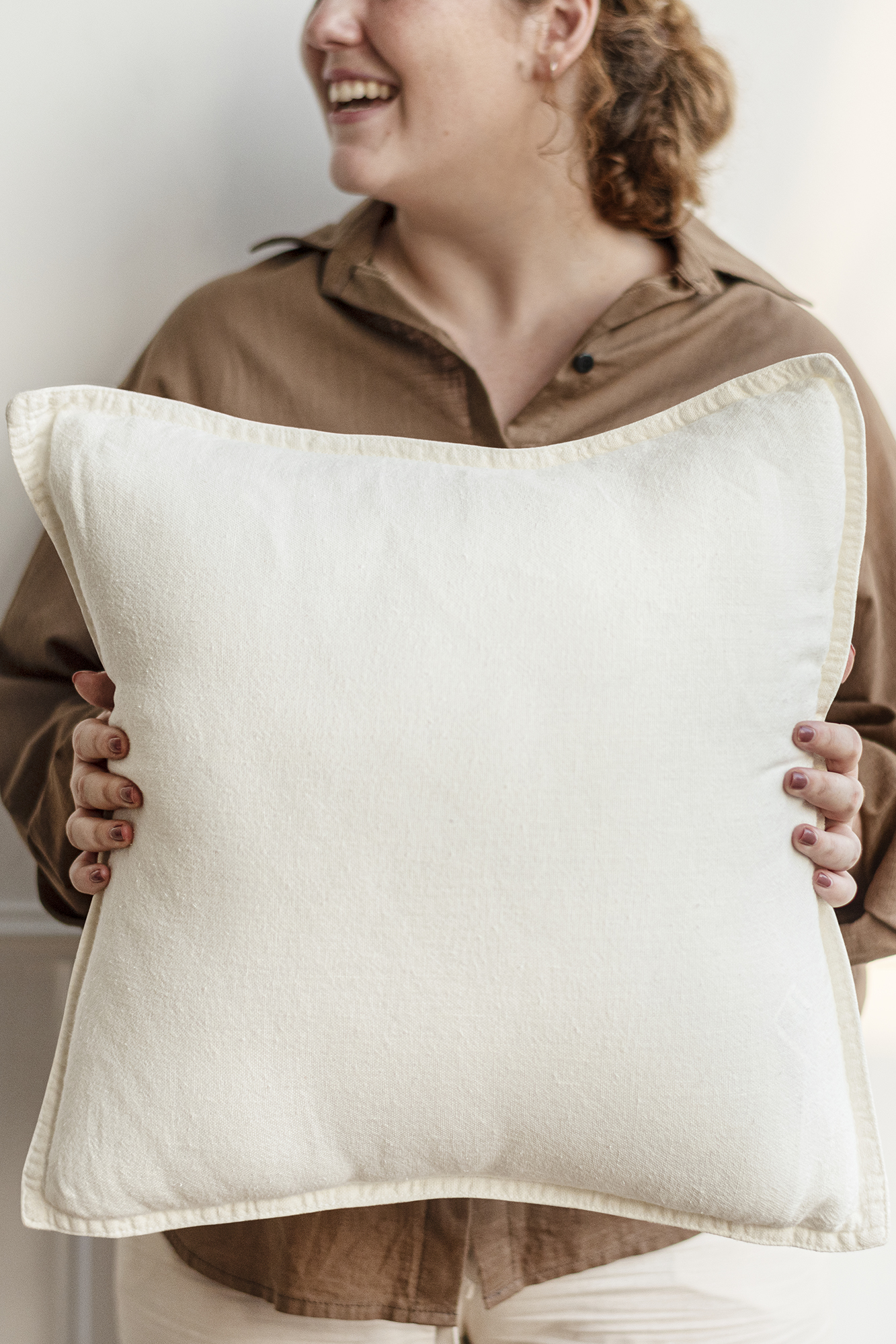 Cream cushion held by a woman interior design